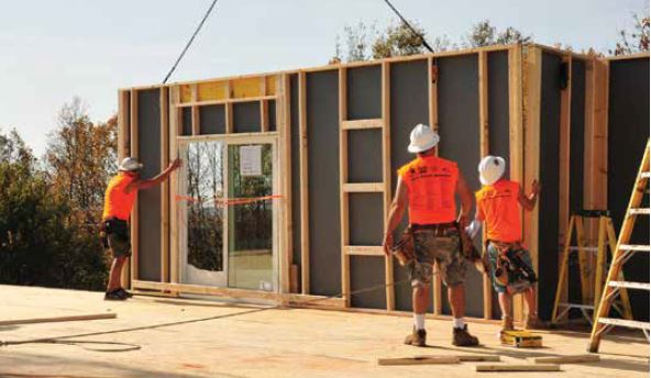 Construction workers putting up wall panels